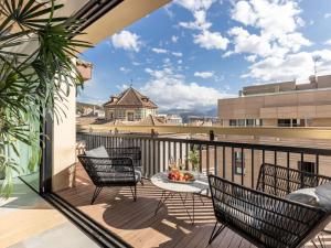 a patio with chairs and a table on a balcony at Luxury Alhambra Penthouse Collection in Granada