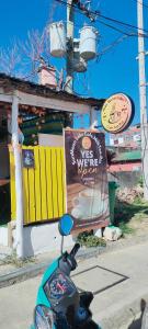 波爾多·格尼拉的住宿－Puerto Galera Transient Kubo Guest Place，停在有标志的餐厅前的摩托车