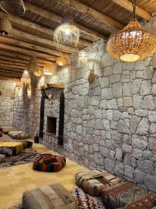 une chambre avec un mur en pierre et une chambre avec des oreillers dans l'établissement KASBAH LA DAME BIJA, à Tassa Ouirgane