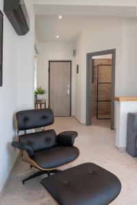 2 schwarze Stühle in einem Wohnzimmer mit Kamin in der Unterkunft VUAR SUITES in Petalidi