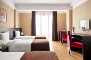 a hotel room with two beds and a desk at Sephia Hotel in Tbilisi City