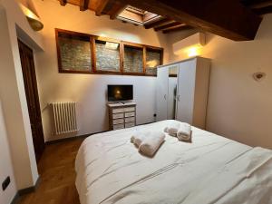 a bedroom with a large white bed with towels on it at Baroni Cortelli Apartments Firenze in Florence