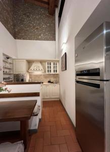 a kitchen with a stainless steel refrigerator and a table at Baroni Cortelli Apartments Firenze in Florence