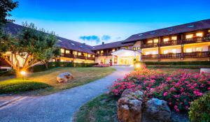 un edificio con flores rosas delante de él en Hotel Rottaler Hof en Bad Birnbach