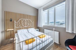 - une chambre avec un lit blanc et une fenêtre dans l'établissement Stöð Guesthouse and apartments, à Grundarfjörður