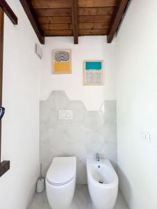 een witte badkamer met een toilet en een wastafel bij Villa La Petite Etoile in Torre delle Stelle