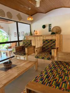 a room with benches and tables in a room at African Treasure Beach Resort in Kokrobite