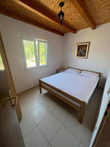 1 dormitorio con cama y ventana en Kuća za odmor Buba en Murter