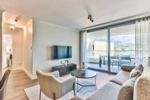 ein Wohnzimmer mit einem Sofa und einem Tisch in der Unterkunft 636 Newlands Peak Luxury Apartment in Kapstadt
