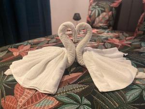 twee zwanen gewikkeld in handdoeken op een bed bij L'escale chez Kalou in La Rivière