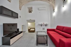 a living room with a red couch and a tv at Vallettastay Standard Apartments in Valletta in Valletta