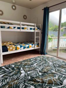 sypialnia z 2 łóżkami piętrowymi i balkonem w obiekcie L'escale chez Kalou w mieście La Rivière
