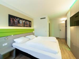 2 łóżka w pokoju zielonym i białym w obiekcie B&B HOTEL Bochum-Hbf w mieście Bochum