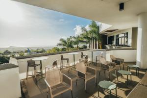 een patio met stoelen en tafels op een balkon bij Voila Bagatelle in Moka