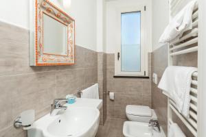 ein Badezimmer mit einem Waschbecken, einem WC und einem Spiegel in der Unterkunft Hotel Cristallo in Rimini