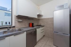 a kitchen with white cabinets and a stainless steel refrigerator at Hotel Cristallo in Rimini