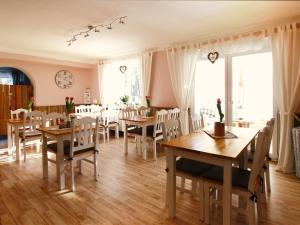 a dining room with wooden tables and chairs at ARRIVEL Pension Haus am Bach in Allershausen