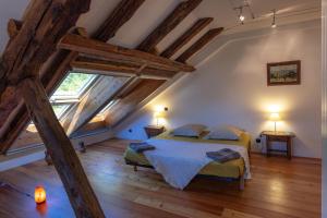 um quarto com uma cama num sótão com vigas de madeira em La Ferme de Beauté em Chateauroux-les-Alpes