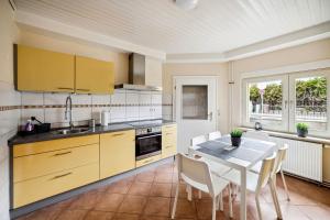a kitchen with yellow cabinets and a table with chairs at Nice Apartments in Hanau in Hanau am Main