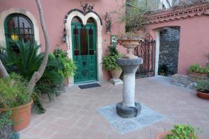 a white and green fire hydrant in front of a brick building at Hotel Villa Nettuno in Taormina