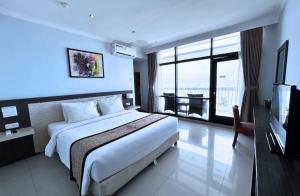 um quarto de hotel com uma cama e uma televisão em Grand Inna Samudra Beach em Cimaja