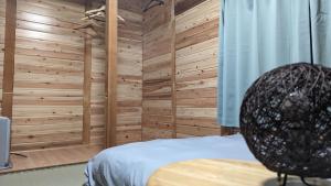 a bedroom with wooden walls and a bed in a room at Yukiumi Furano in Furano