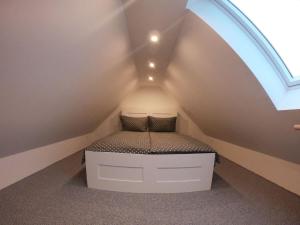 uma pequena cama num quarto com um sótão em Ferienhaus Melody em Ralswiek