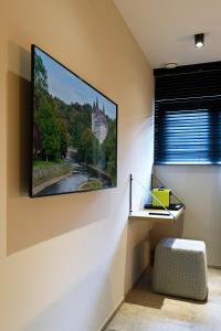 TV de pantalla plana colgada en la pared en DURBUY SUITES, en Durbuy
