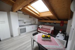 a living room with a table and a kitchen at Apt Ochner Grape 2 Pergine in Pergine Valsugana