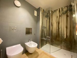 La salle de bains est pourvue d'une douche, de toilettes et d'un lavabo. dans l'établissement Sui Generis - Aosta Urban Apartments, à Aoste