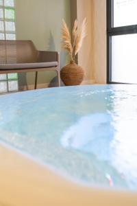 a table in a room with a potted plant at Kyriad Prestige Residence & Spa Cabourg-Dives-sur-Mer in Dives-sur-Mer