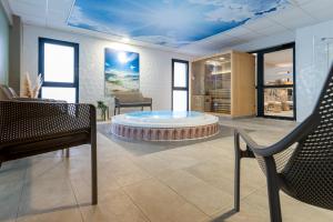 a room with a table and a chair in it at Kyriad Prestige Residence & Spa Cabourg-Dives-sur-Mer in Dives-sur-Mer