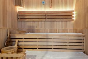 a sauna with a tub and a clock on the wall at Kyriad Prestige Residence & Spa Cabourg-Dives-sur-Mer in Dives-sur-Mer