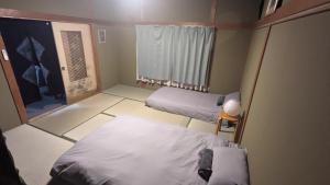 a small room with two beds and a window at Yukiumi Furano in Furano