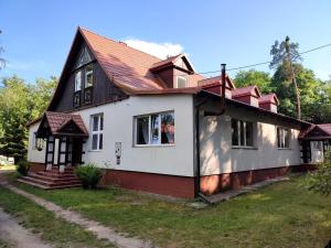 een huis met een rood dak bij Apartament willa Radosna in Garbatka-Letnisko