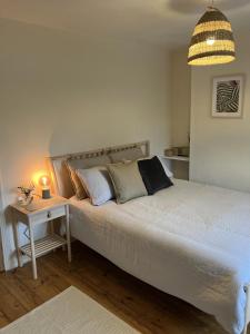 a bedroom with a large white bed with a night stand at 3 bedroom house in Bedminster near Wapping Wharf in Bristol