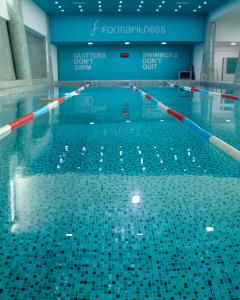 a swimming pool filled with water in a building at Park Azure Comfortable Apartment in Baku
