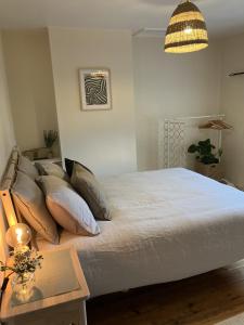 um quarto com uma cama com almofadas e uma mesa em 3 bedroom house in Bedminster near Wapping Wharf em Bristol