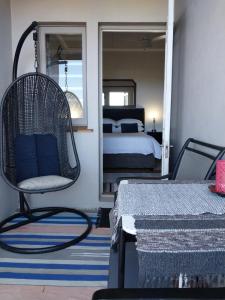 Habitación con silla, cama y espejo. en The Trailhouse en Bettyʼs Bay