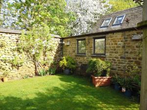 una casa in mattoni con piante in un cortile di Wonderful Picturesque Countryside Cottage a Bloxham