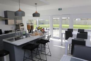 a kitchen with a counter with chairs and a table at Causeway guest accommodation in Bushmills