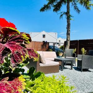 a patio with a couch and chairs and flowers at Hotel Seven 7 in Kalisz