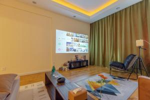 uma sala de estar com um sofá e uma mesa em Dalian Baobab Apartment em Dalian