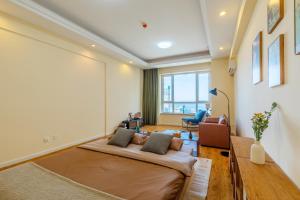 ein Schlafzimmer mit einem großen Bett in einem Zimmer in der Unterkunft Dalian Baobab Apartment in Dalian