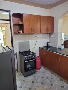 Il comprend une cuisine équipée d'une cuisinière et d'un comptoir. dans l'établissement Gloria House, à Nairobi