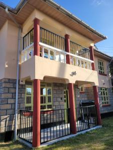 a house with red columns and a balcony at Gloria House in Nairobi