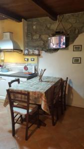 a dining room table with chairs and a tv on the wall at Chalet in pietra in Antey-Saint-André