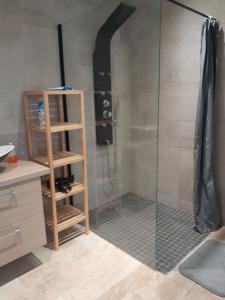 La salle de bains est pourvue d'une douche avec une porte en verre. dans l'établissement Au delà des Remparts, à Montreuil-sur-Mer