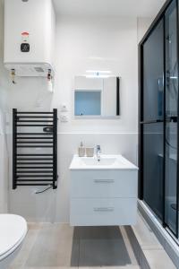 a white bathroom with a sink and a toilet at Joli T2- cocooning - wifi fibre - lave-linge in Grenoble