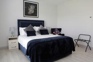 um quarto com uma cama king-size e uma cadeira em Causeway guest accommodation em Bushmills